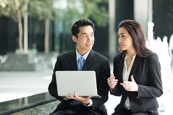 Businessman meets with businesswoman over cloud tablet devices