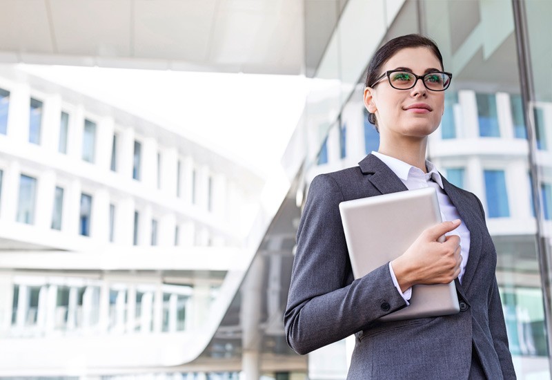 Young business woman holds tablet outside
