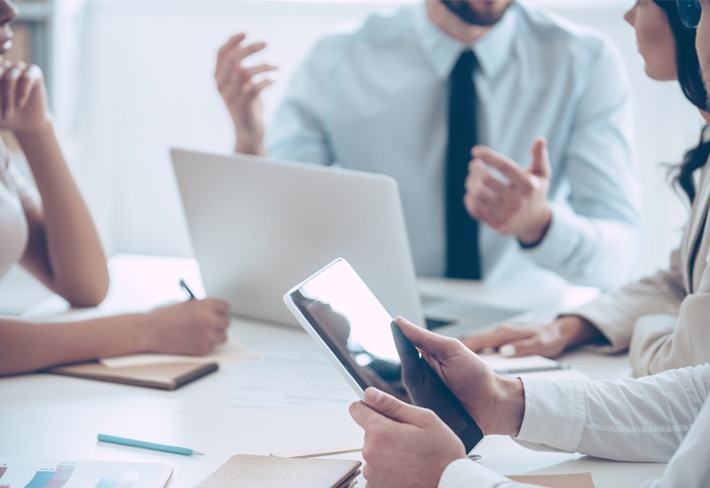 Close up of business professionals having meeting over tablet computer