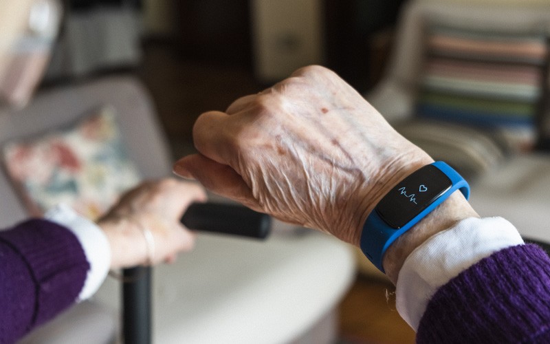 Elderly patient using IoT wearable device tracking her health