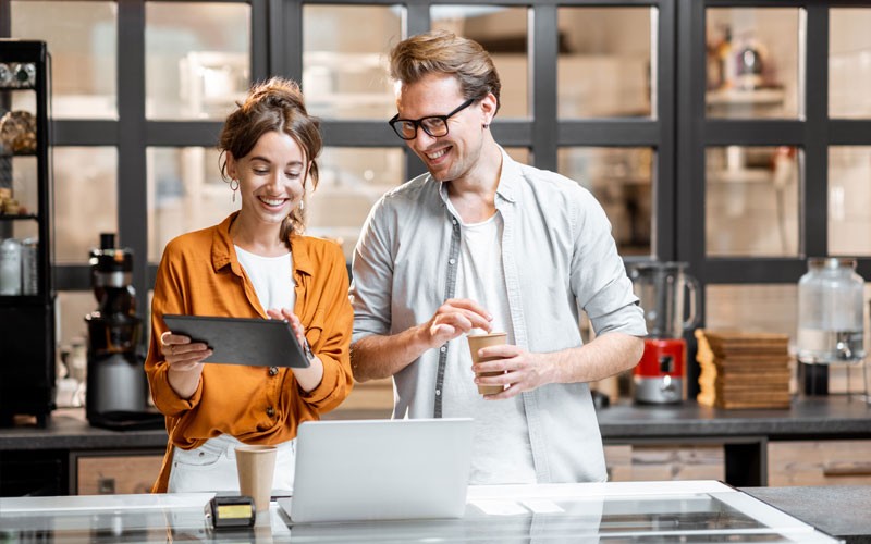 smiling-cafe-workers-on-tablet-device